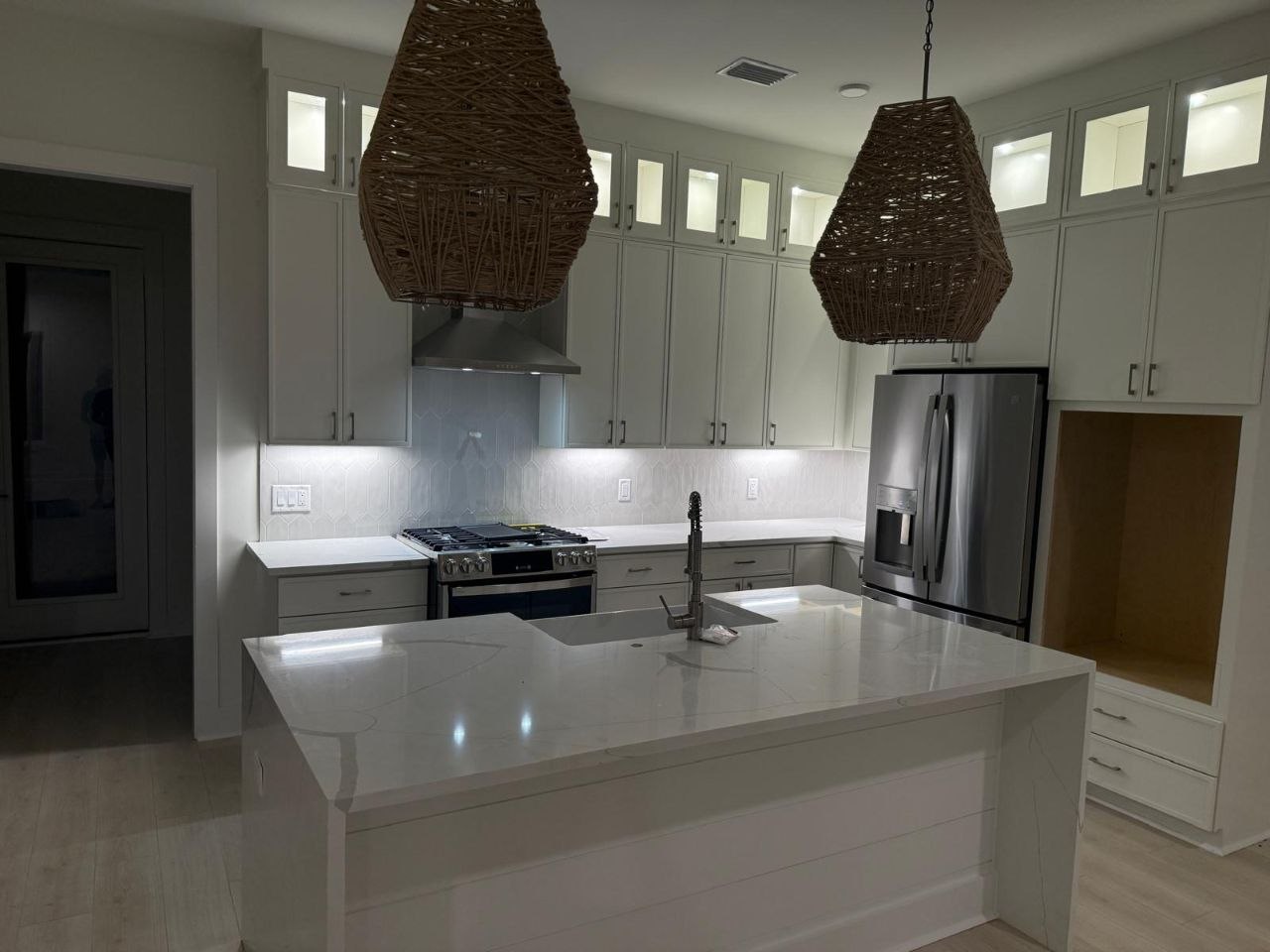 Bright kitchen with rattan pendants and quartz island